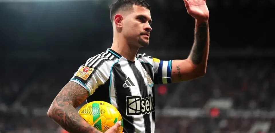 Jugador de Newcastle levantando la mano con balón