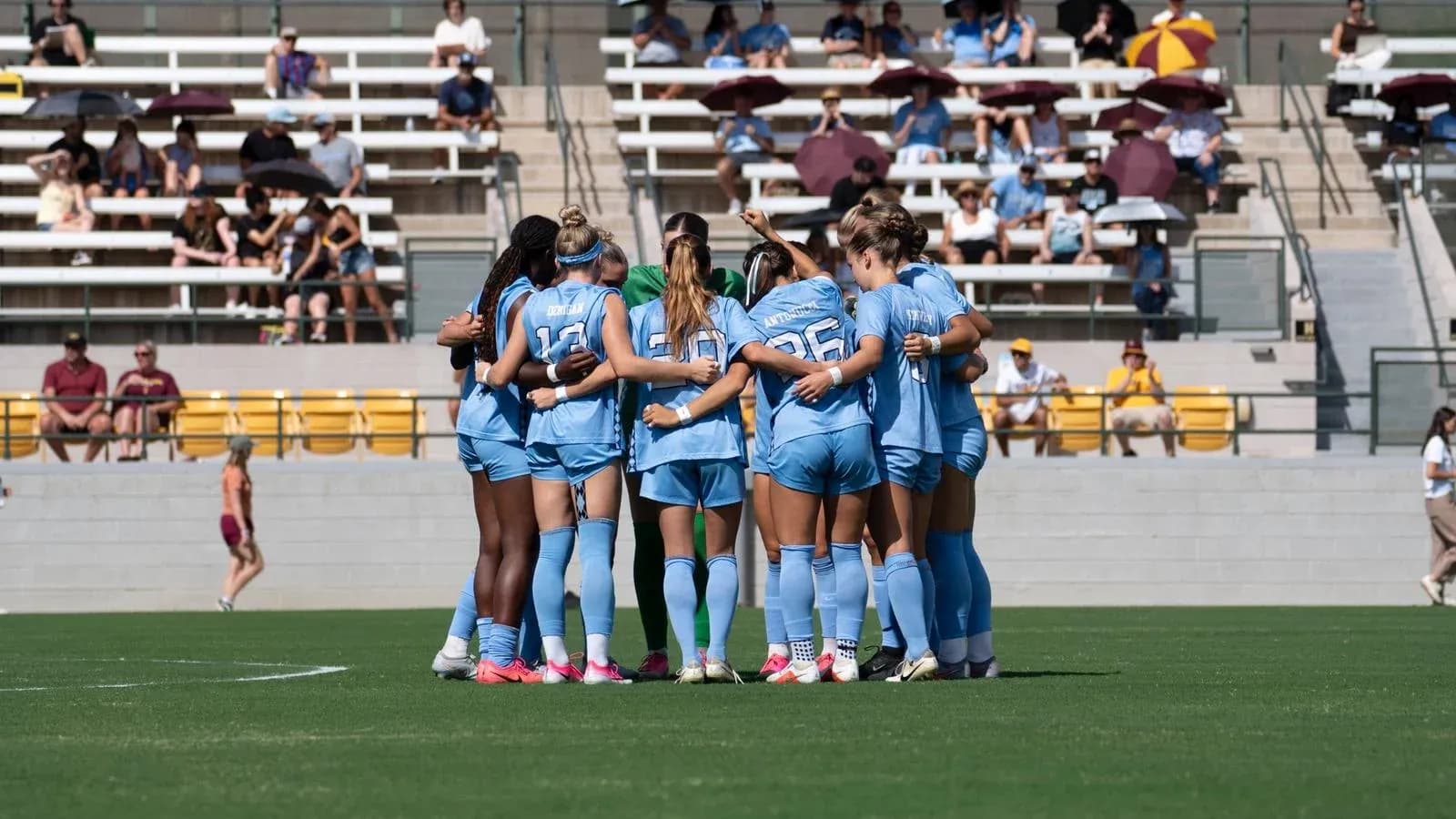 Equipo de fútbol femenino en círculo durante calentamiento
