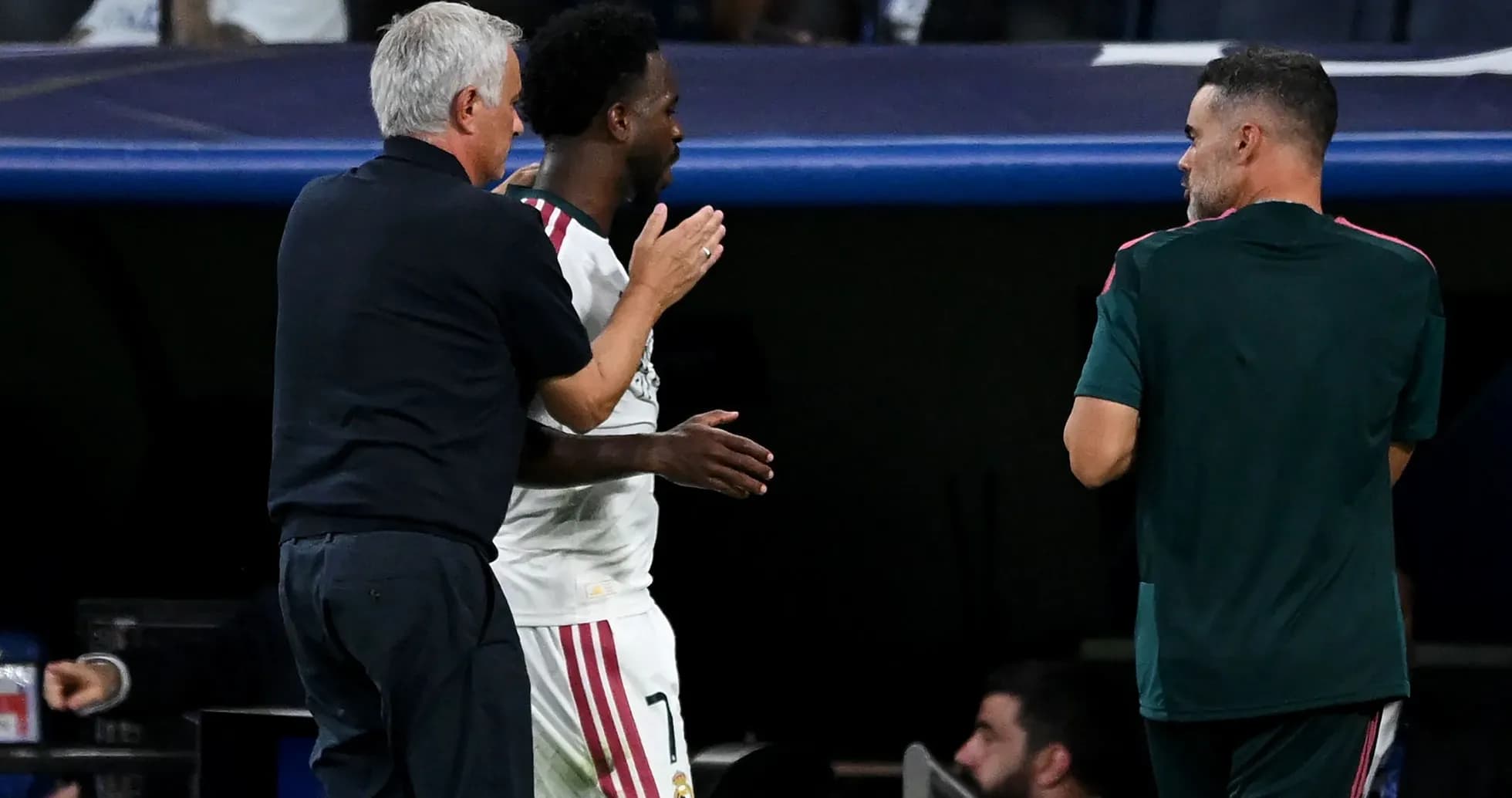 Entrenador y jugador conversando en el banquillo