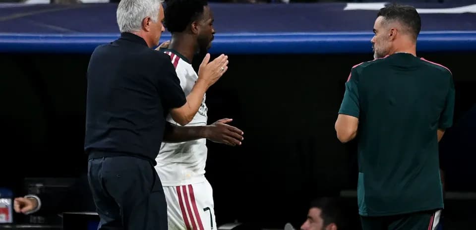 Entrenador y jugador conversando en el banquillo