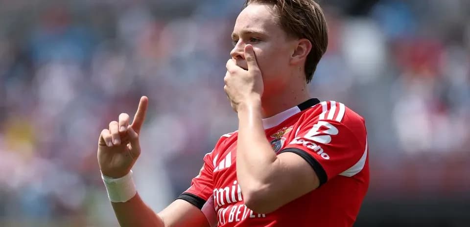 Jugador de fútbol celebrando con la mano levantada