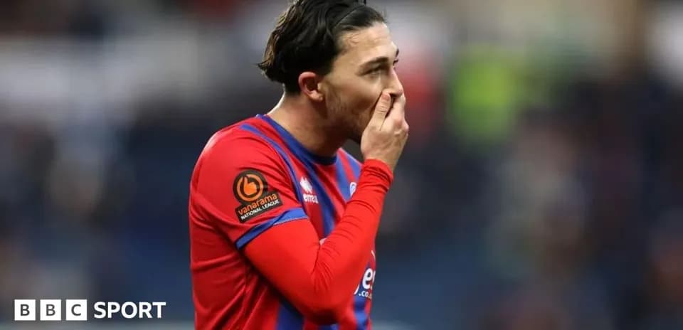 Jugador con camiseta roja mostrando gesto de preocupación