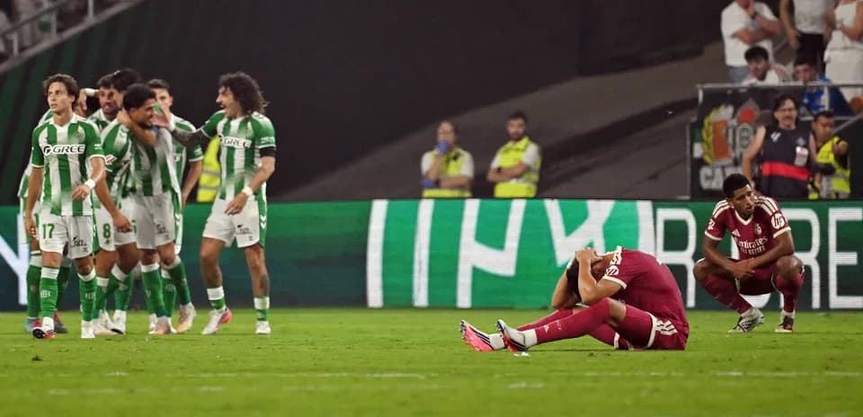 Jugadores de Betis celebrando, rival en el suelo