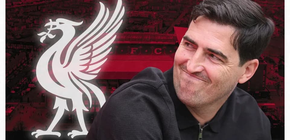Entrenador sonriendo frente al logo de Liverpool FC