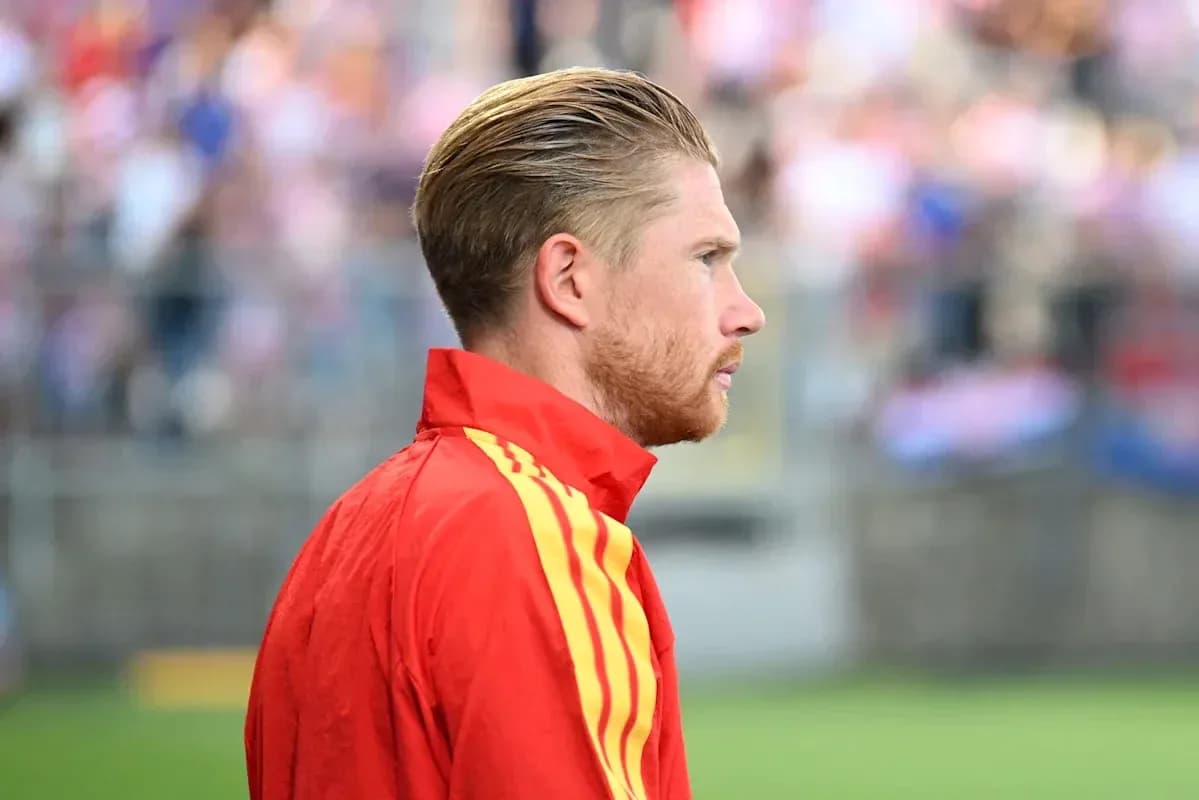 Jugador en uniforme rojo observando el partido