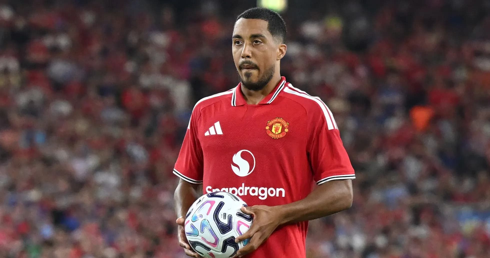 Jugador de Manchester United sosteniendo un balón en campo