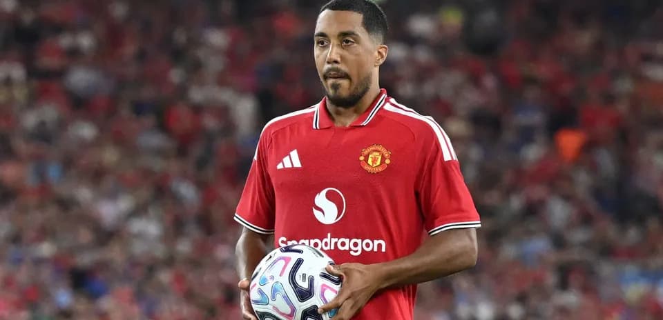 Jugador de Manchester United sosteniendo un balón en campo