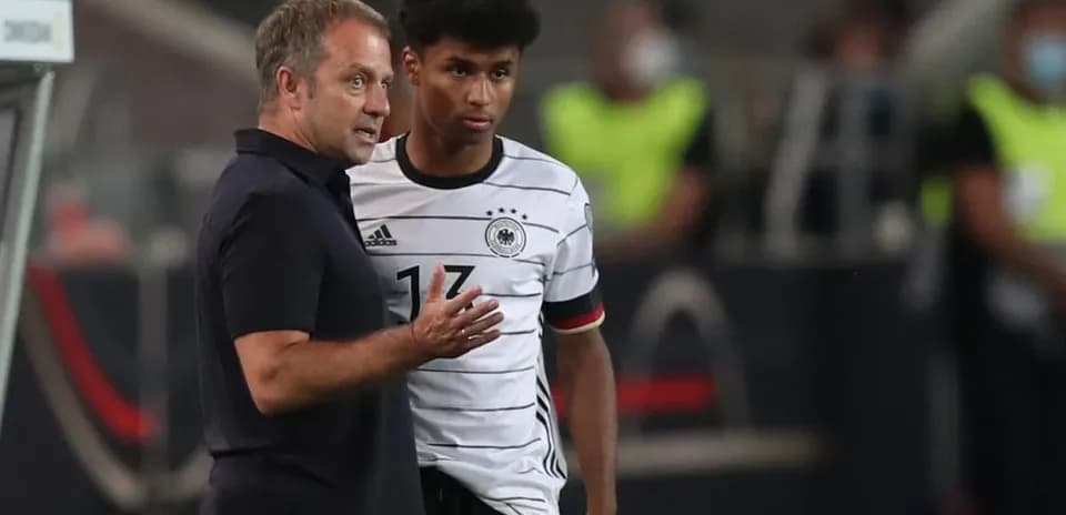 Entrenador hablando con jugador de Alemania en el banquillo