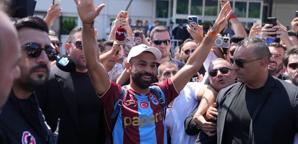 Jugador saludando a la multitud rodeado de fanáticos