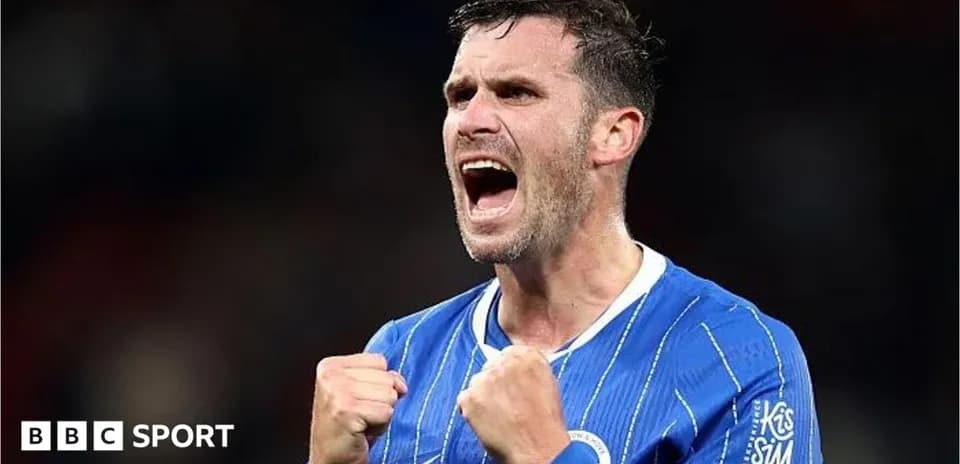 Jugador celebrando con puños cerrados en uniforme azul