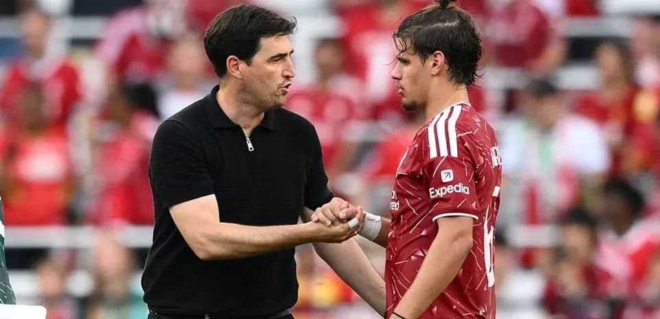 Entrenador conversando con jugador en el campo