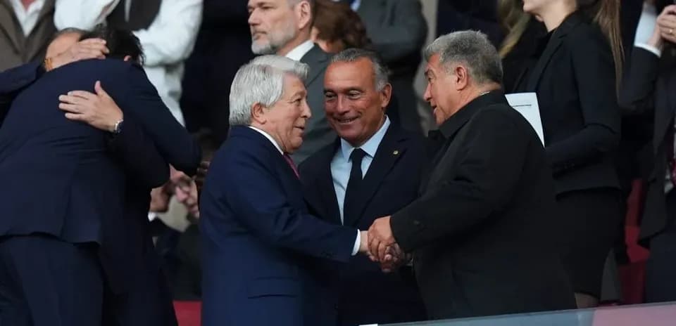 Dirigentes saludándose en el palco del estadio
