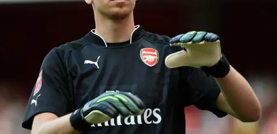 Portero de Arsenal ajustando sus guantes en el campo