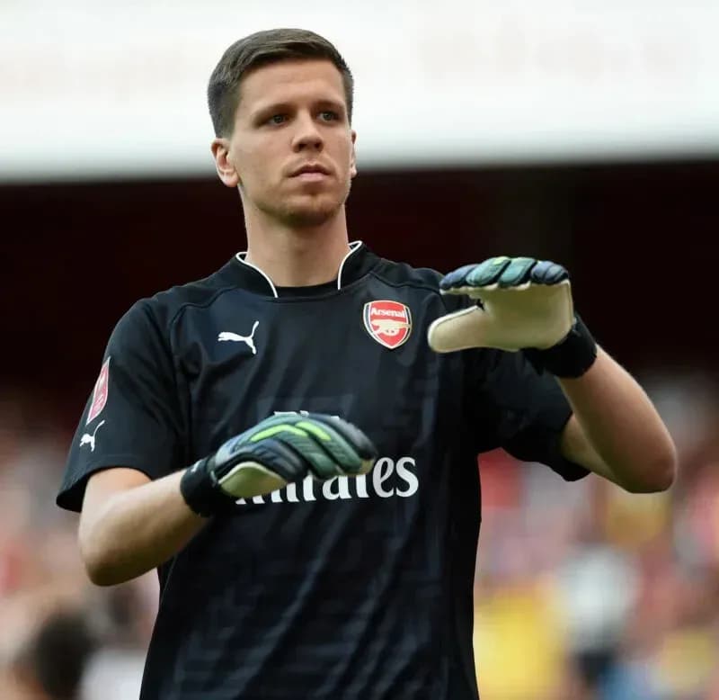 Portero de Arsenal ajustando sus guantes en el campo