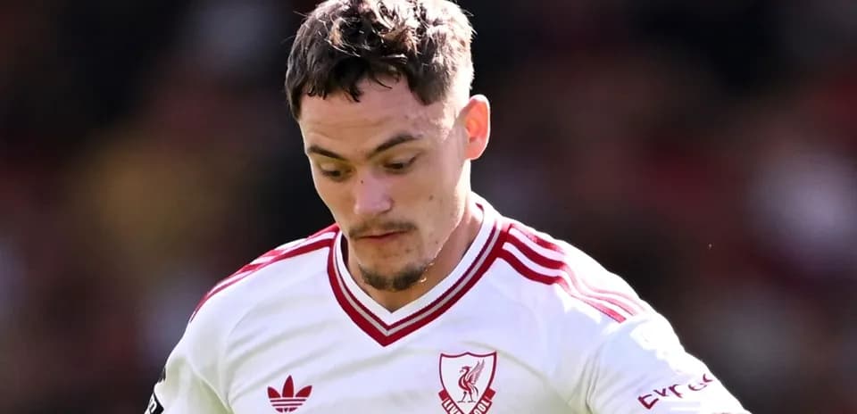 Jugador de Liverpool con camiseta blanca en acción
