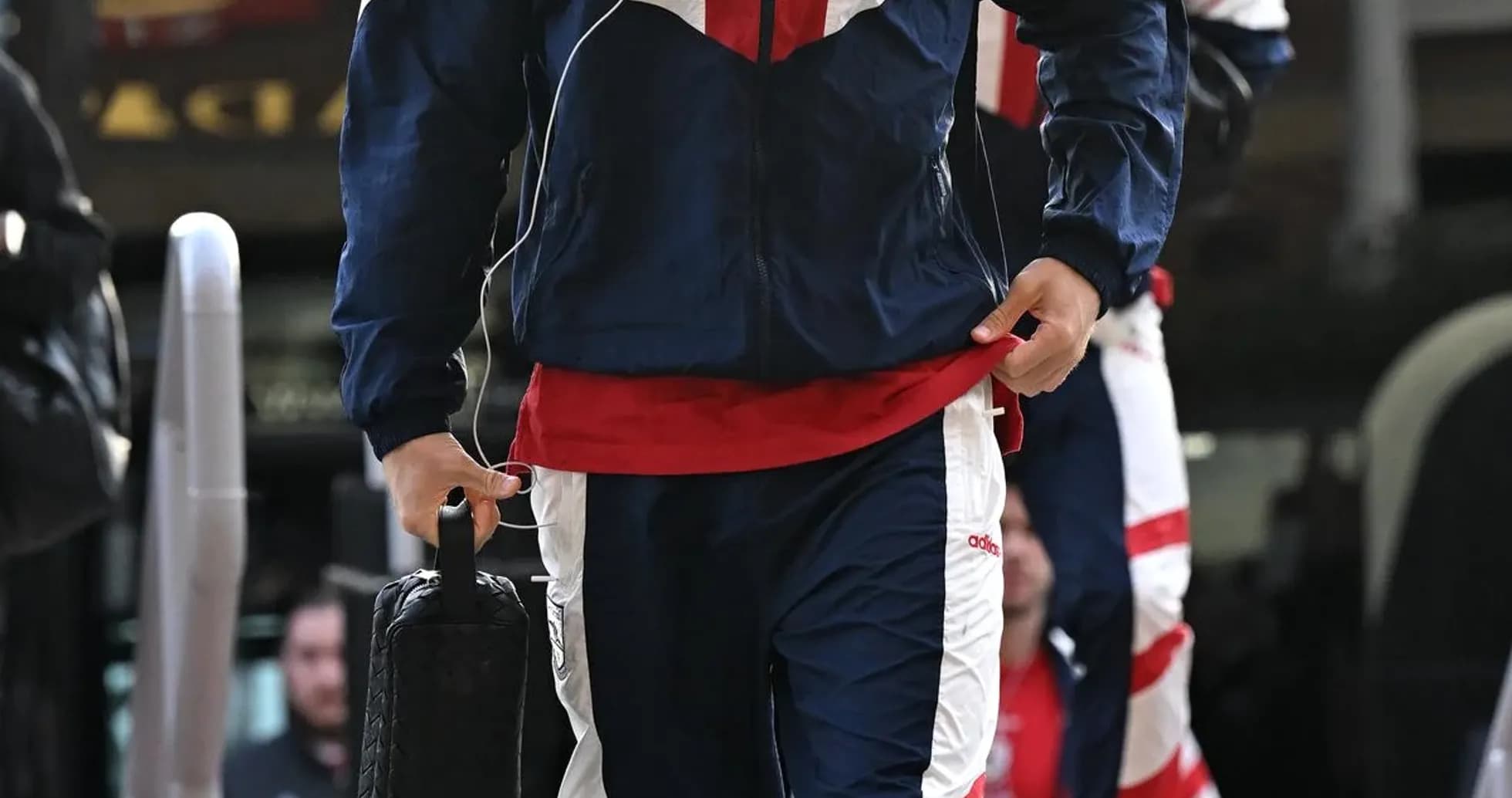 Jugador llegando con chándal y auriculares