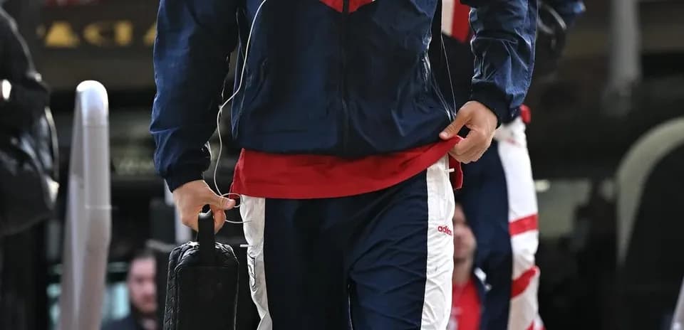 Jugador llegando con chándal y auriculares