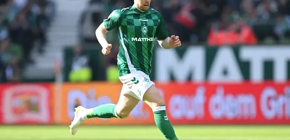 Jugador corriendo con el balón en el campo