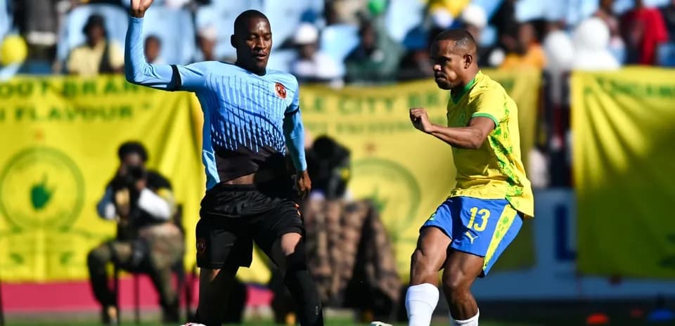 Jugador de amarillo pateando el balón durante partido