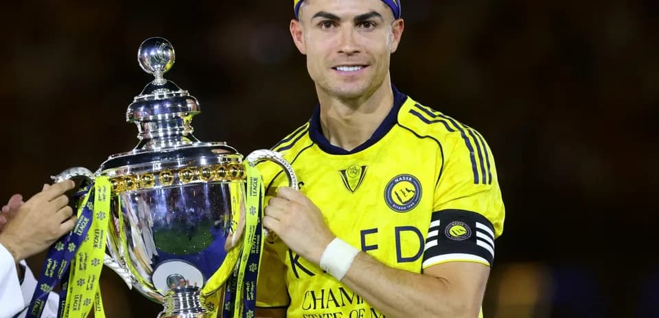 Jugador sosteniendo trofeo en uniforme amarillo