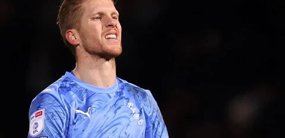 Portero con camiseta azul en acción durante partido