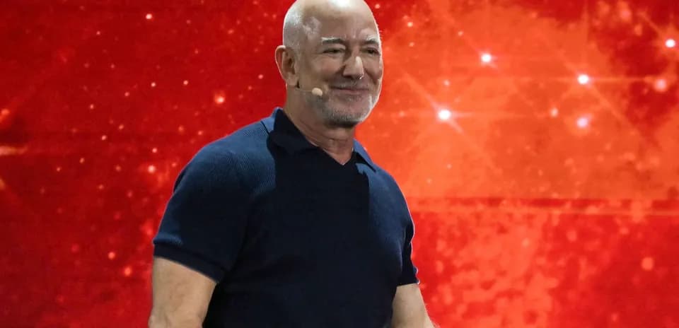 Hombre sonriendo en escenario con fondo rojo