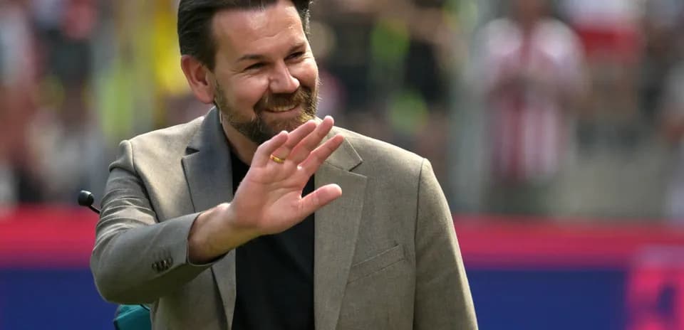 Hombre sonriendo y saludando en el estadio