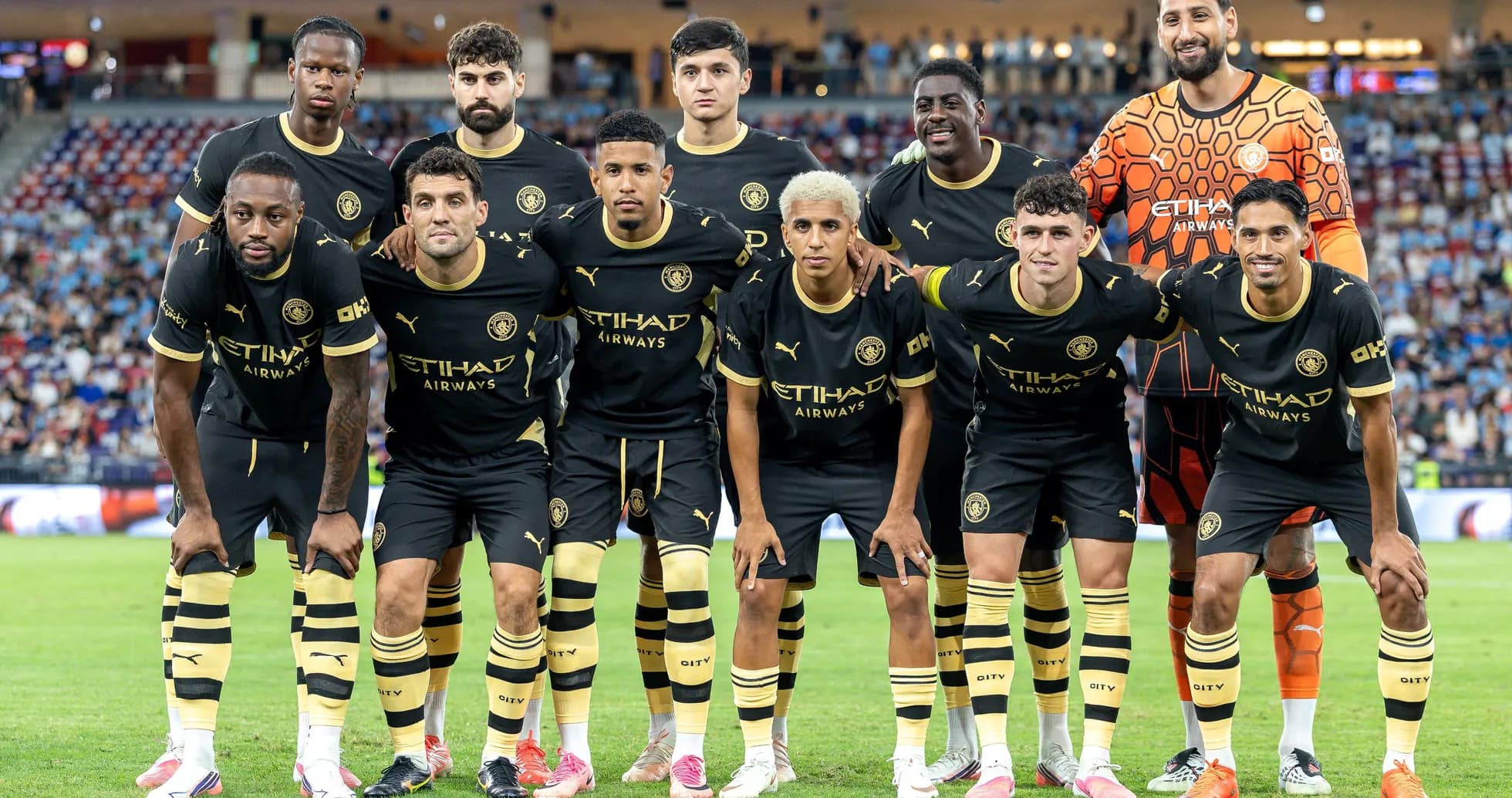 Equipo de fútbol posando en uniforme negro y dorado