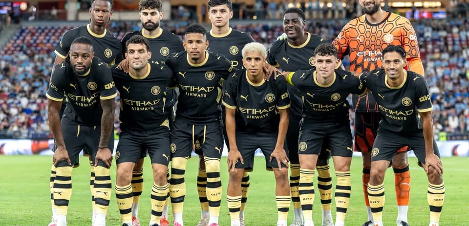 Equipo de fútbol posando en uniforme negro y dorado