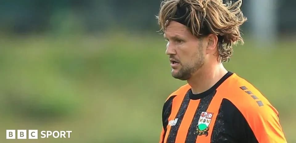Jugador con camiseta naranja y negra en el campo