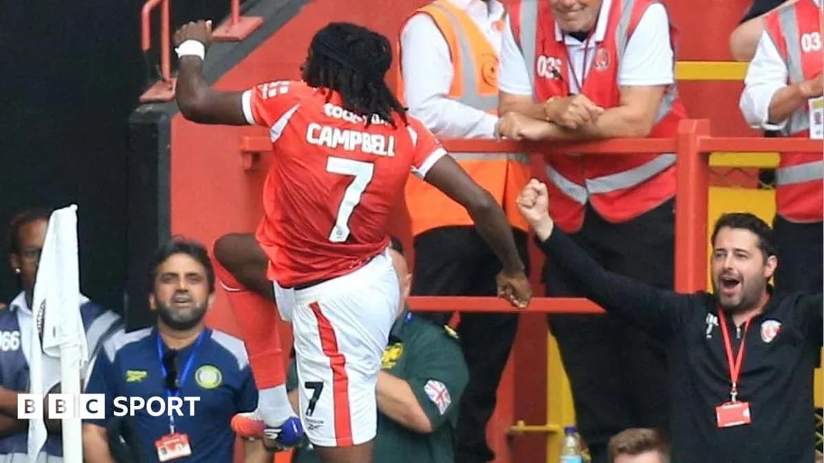 Jugador celebrando un gol con aficionados en el estadio