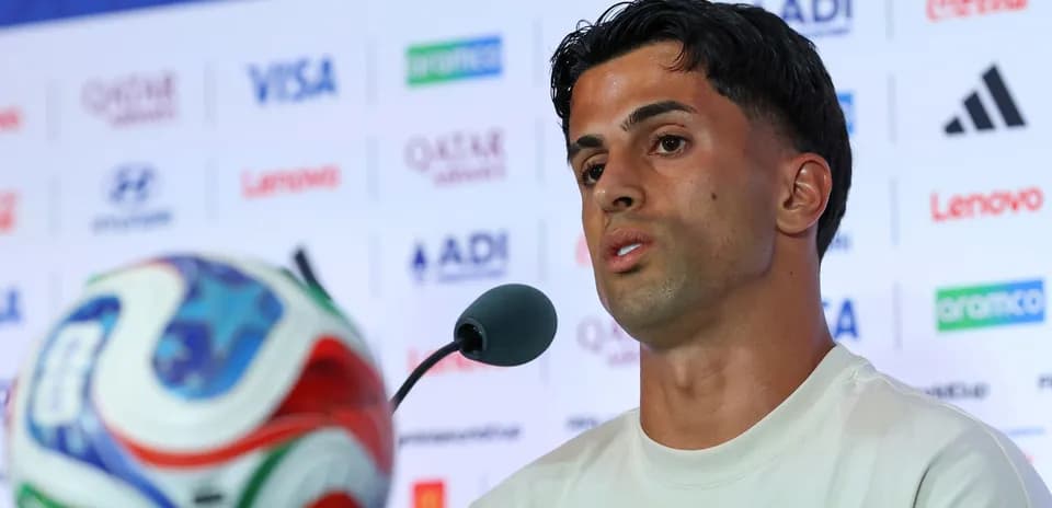 Jugador hablando en conferencia de prensa con balón