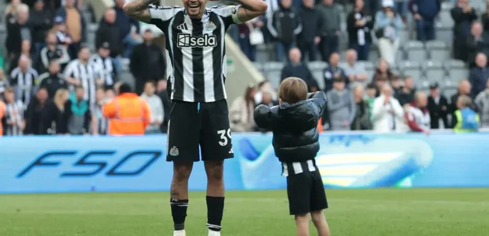 Jugador de Newcastle celebrando con un niño en el campo