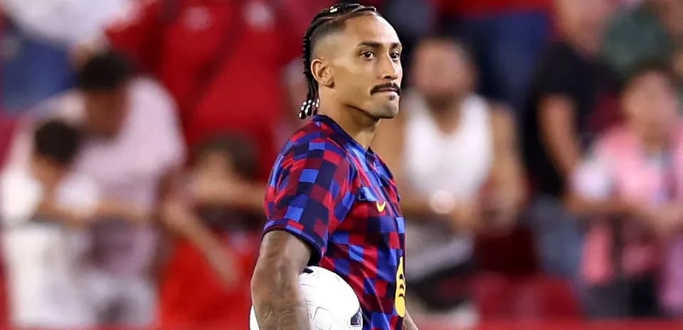 Jugador de fútbol sosteniendo un balón en el campo