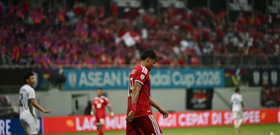 Jugador caminando cabizbajo durante partido de fútbol