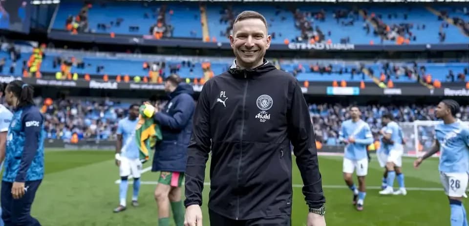 Entrenador sonriente saliendo del campo de juego