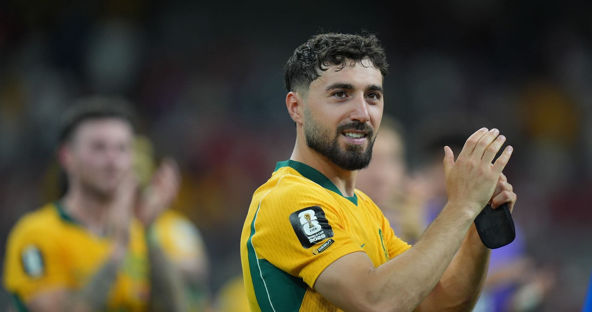 Jugador aplaudiendo con camiseta amarilla de Australia