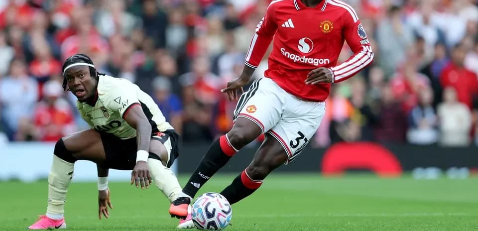 Jugador de Manchester United driblando balón en partido