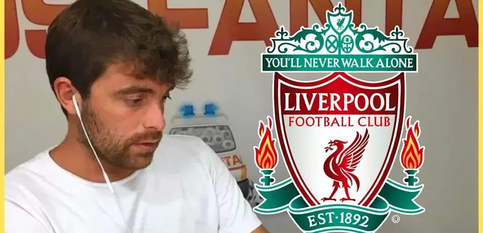 Hombre con auriculares junto al escudo de Liverpool