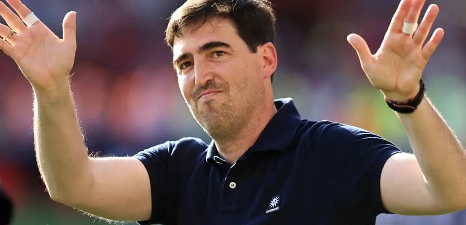Entrenador saludando a la afición en el campo