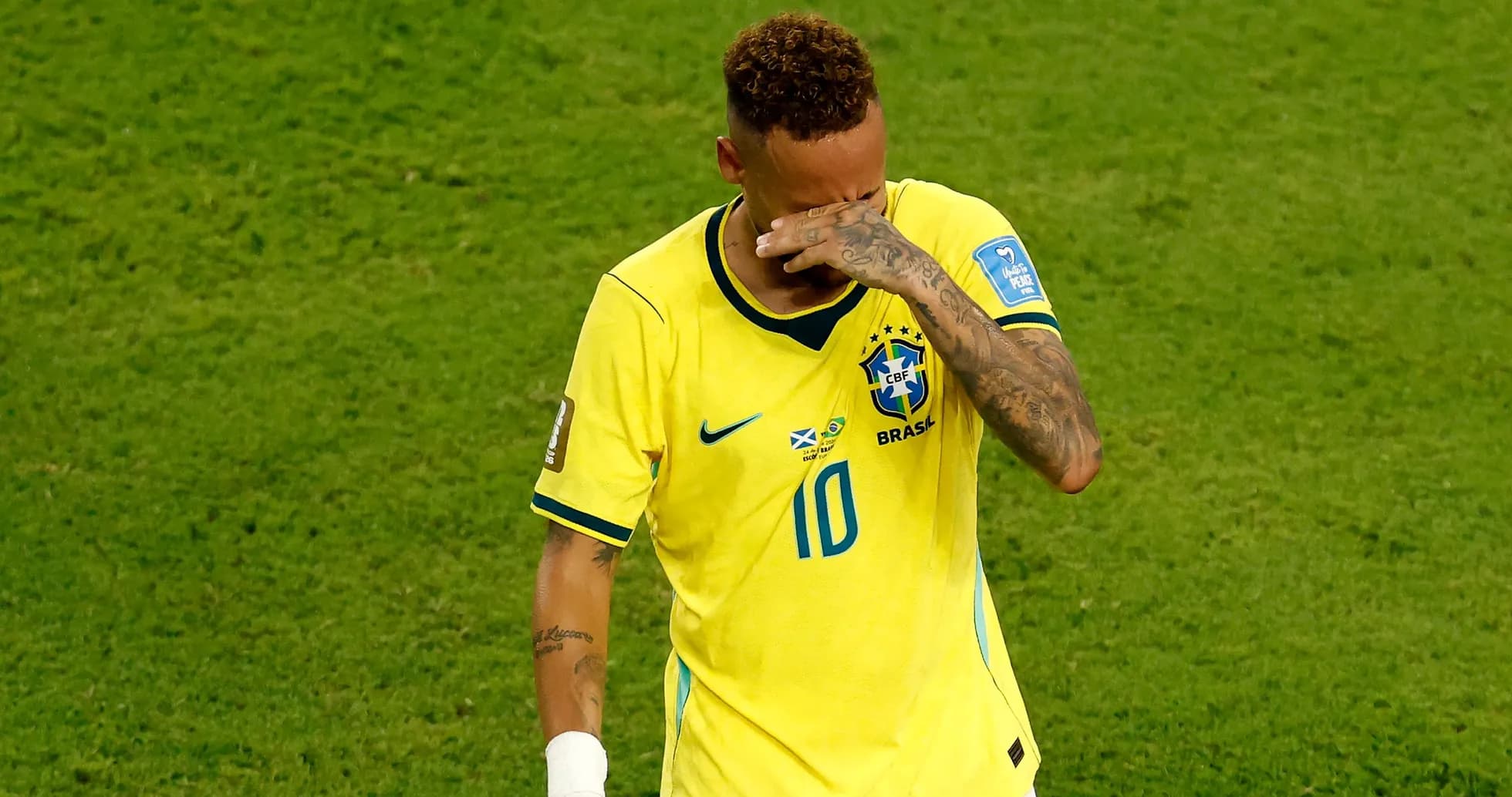 Jugador de Brasil lamentándose en el campo de fútbol