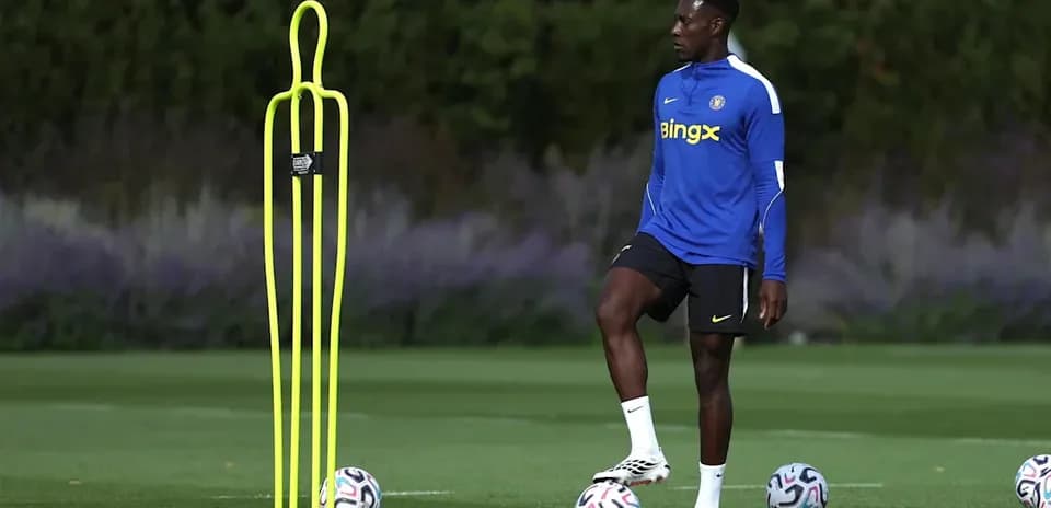 Jugador de fútbol entrenando junto a conos y balones