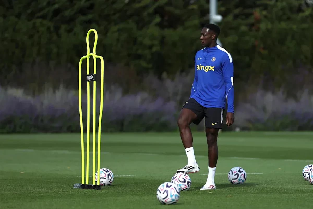 Jugador de fútbol entrenando junto a conos y balones