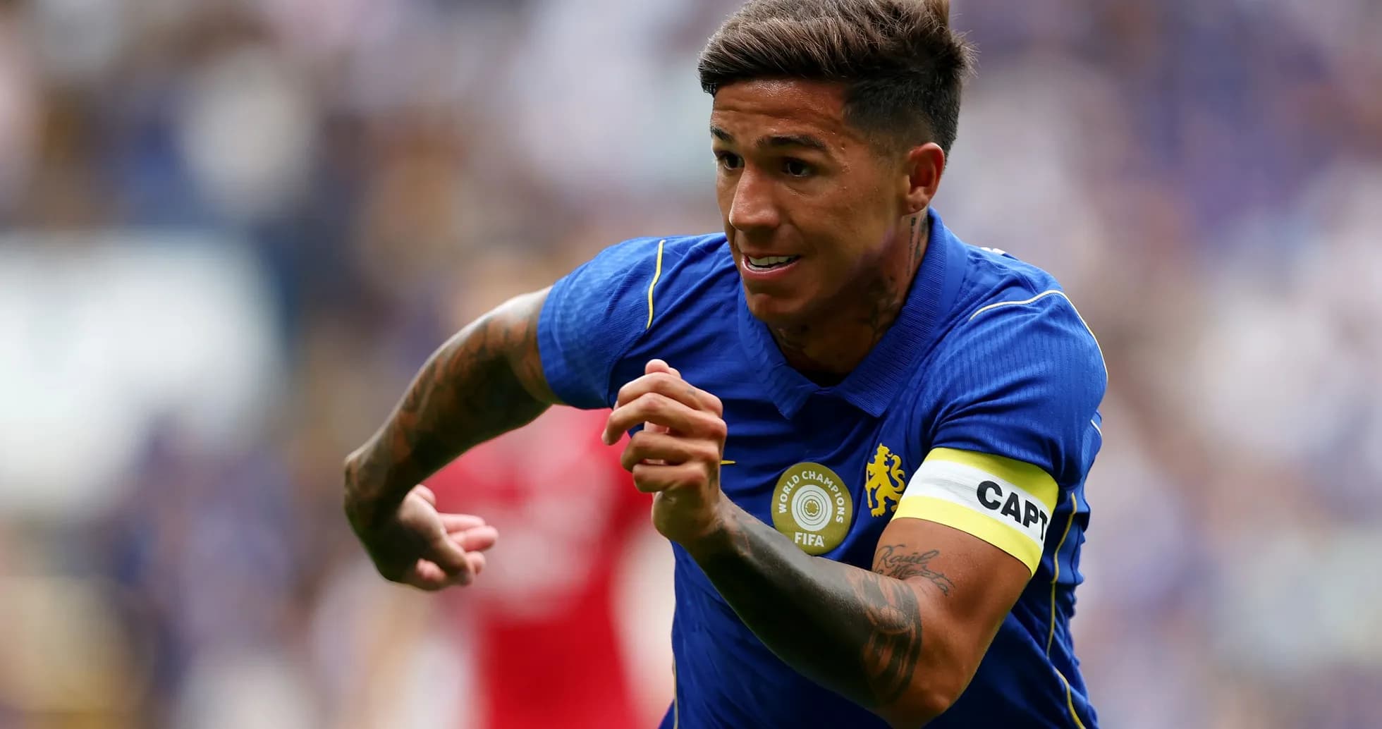 Jugador corriendo con camiseta azul y brazalete de capitán