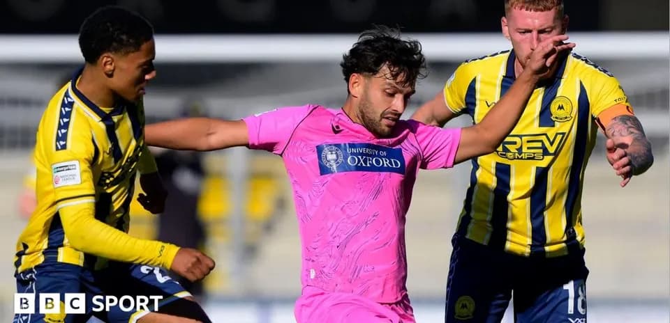 Jugador en camiseta rosa es desafiado por dos oponentes
