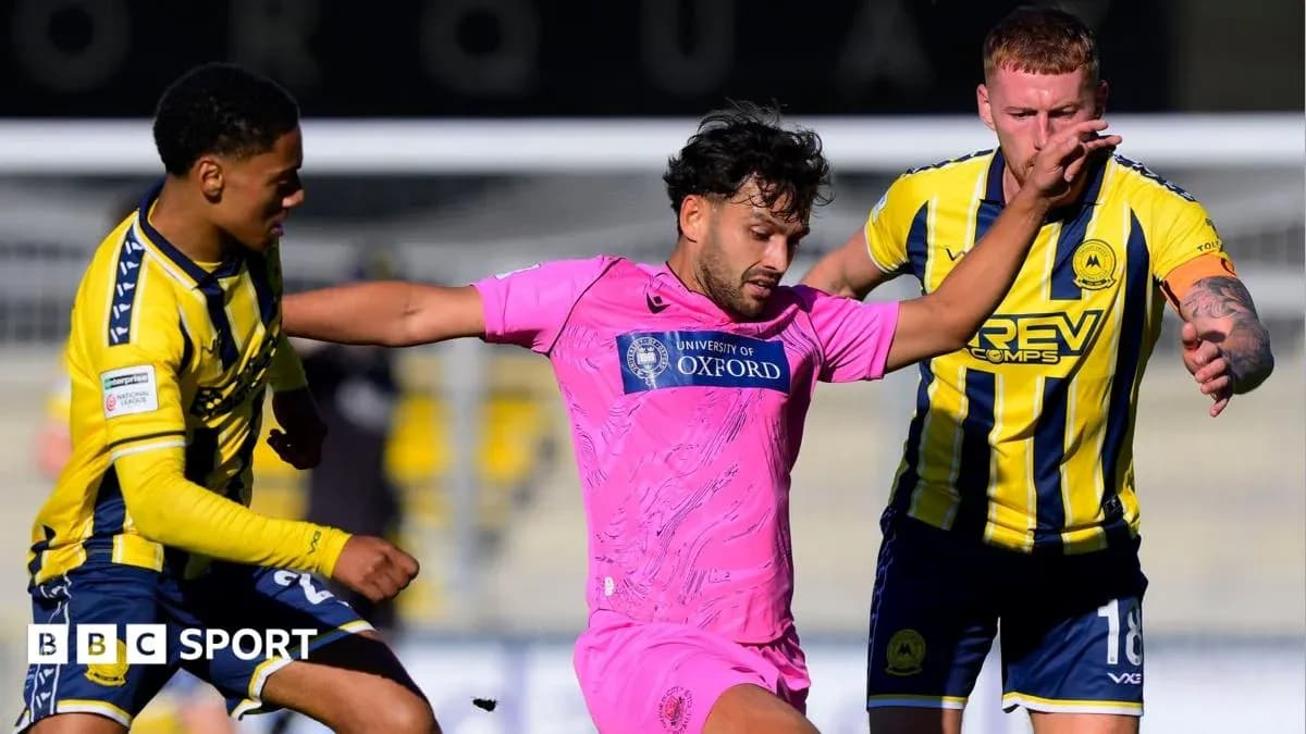 Jugador en camiseta rosa es desafiado por dos oponentes
