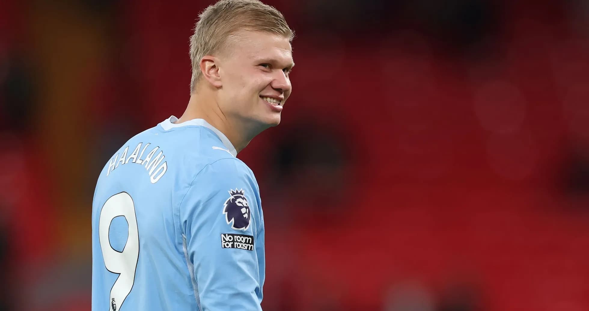 Jugador sonriendo con camiseta de Manchester City