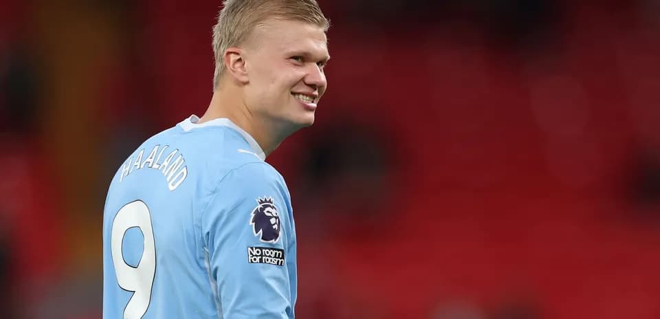 Jugador sonriendo con camiseta de Manchester City