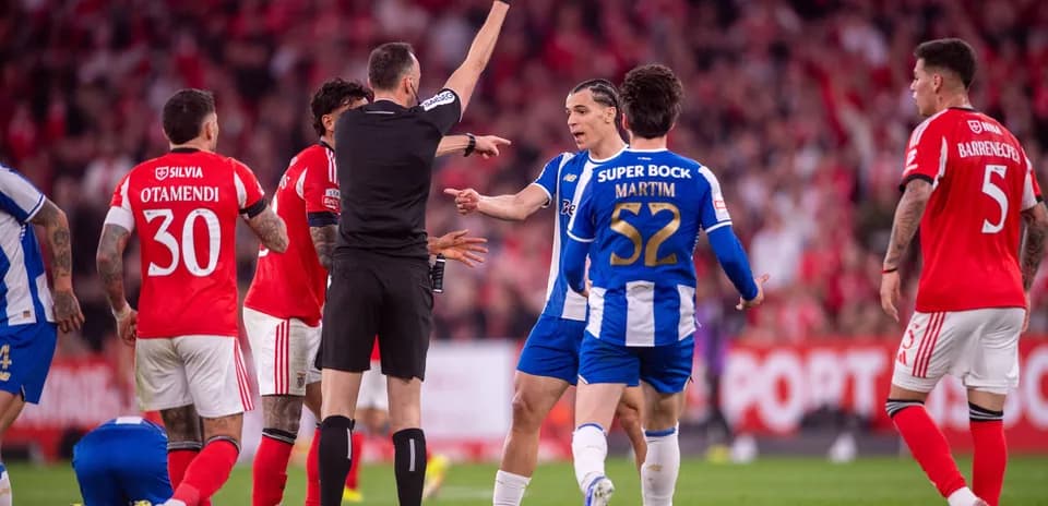 Árbitro mostrando tarjeta amarilla a jugador