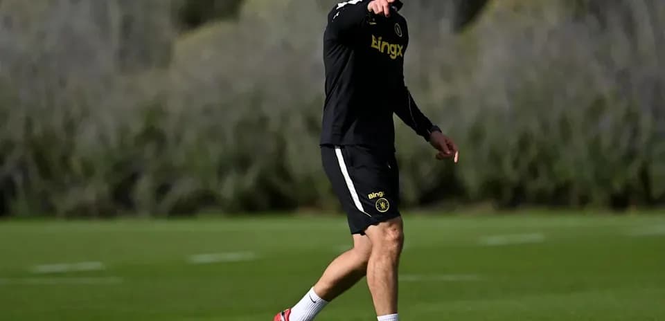 Entrenador dirigiendo a jugadores en el campo de entrenamiento